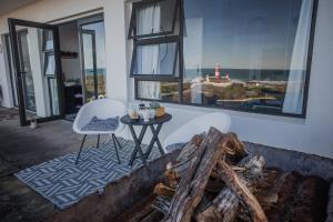 a living room with a table and chairs and windows at HIGH LEVEL 26 in Agulhas
