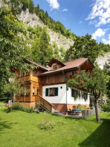 a large wooden house in front of a mountain at Apartment Haus Toplitzsee nahe dem Grundlsee und Toplitzsee in Gössl