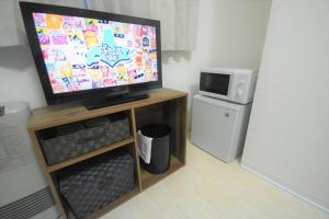 Tresor Misono - Vacation STAY 7905 في سابورو: تلفزيون بشاشة مسطحة جالس على منصة خشبية