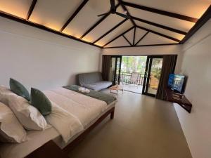 a bedroom with a bed and a tv and a balcony at DIANAO BEACH CLUB AND RESORT in Dilasag