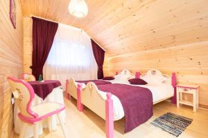 1 dormitorio con 2 camas y 2 sillas en Cabana cu Flori, en Porumbacu de Sus