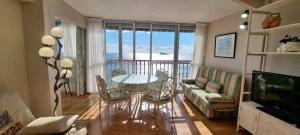 a living room with a table and a view of the ocean at Las Damas in Benidorm