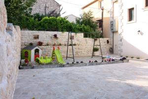 a playground in a courtyard with a swing set at Apartment LuVi in Korčula