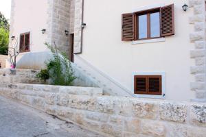a house with a stone wall and stairs at Apartment LuVi in Korčula