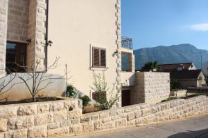 a building with a stone wall next to a street at Apartment LuVi in Korčula