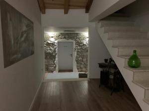 einen Flur mit einer weißen Tür und einer Steinmauer in der Unterkunft Accommodation TRI MURVE in Plomin