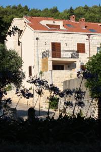 a large stone house with a balcony on top of it at Apartment LuVi in Korčula