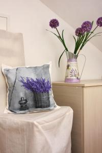 a pillow on a table with purple flowers in a vase at Apartment LuVi in Korčula