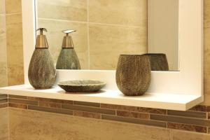 three vases sitting on a shelf in a bathroom at Apartment LuVi in Korčula