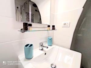 une salle de bain blanche avec un lavabo et un miroir dans l'établissement Lùnia Home, à Bari 25 autres photos