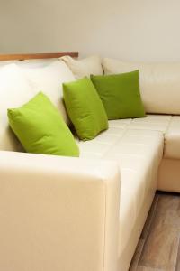 a white couch with two green pillows on it at Apartment LuVi in Korčula