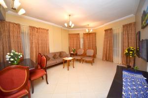 ein Wohnzimmer mit einem Sofa, einem Tisch und Stühlen in der Unterkunft Emirates Stars Hotel Apartments Sharjah in Schardscha