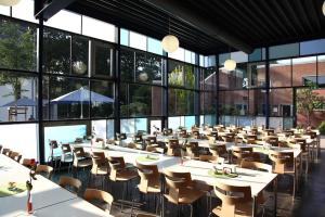 a dining room with tables and chairs and windows at Haus Venusberg Jugendbildungsstätte Bonn in Bonn