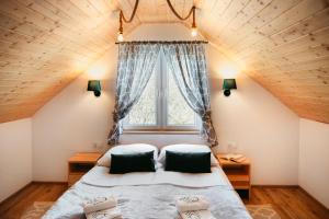 ein Schlafzimmer mit einem großen Bett und einem Fenster in der Unterkunft Przystanek Roztocze in Susiec