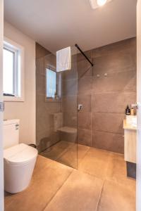 a bathroom with a toilet and a shower at Amaroo 1 - Freycinet Holiday Houses in Coles Bay