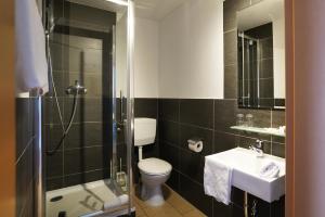 a bathroom with a toilet and a shower and a sink at Hotel Gasthof Metzgerei Lamm in Geiselwind