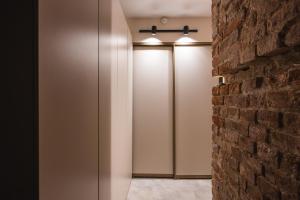 a corridor with white stalls with a brick wall at Caps Hotel на Остоженке in Moscow