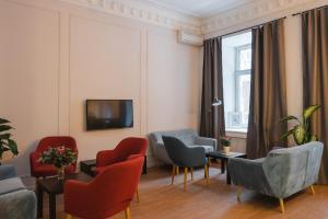 a living room with chairs and a tv on the wall at Caps Hotel на Остоженке in Moscow