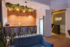 a bar with a blue couch in front of a brick wall at Caps Hotel на Остоженке in Moscow