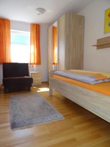 1 dormitorio con 1 cama, 1 silla y 1 ventana en Ferienwohnung Keßler en Bad Hindelang