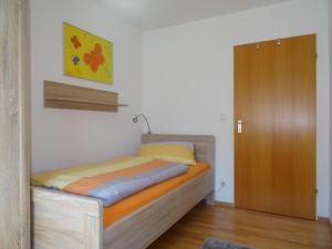 1 dormitorio con 1 cama y puerta de madera en Ferienwohnung Keßler en Bad Hindelang