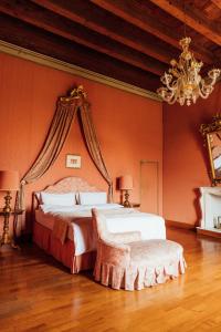 a bedroom with a large bed and a chandelier at Buonvisi B&B in Lucca