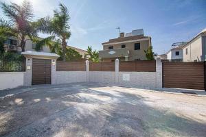 a driveway in front of a house with a fence at Modern beach villa with parking and private pool in Torremolinos