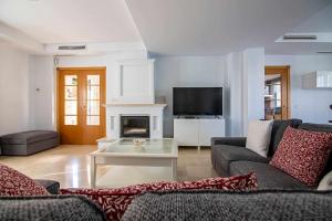 un soggiorno con divano e camino di Modern beach villa with parking and private pool a Torremolinos