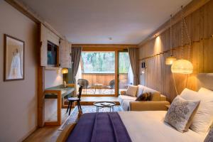 a hotel room with a bed and a living room at Vila Planinka Boutique Hotel in Zgornje Jezersko