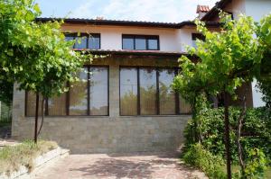 a house with large windows and trees in front of it at Villa Bignonia in Varna City