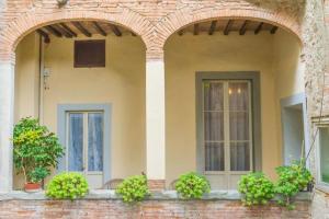 une maison avec deux fenêtres et un mur en briques dans l'établissement Albergo Casentino, à Poppi