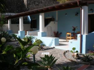 a house with blue and white walls and plants at Eolie Appartamenti per Vacanze in Lipari