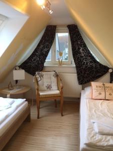 a attic room with two beds and a chair at Mar Baltico in Zingst
