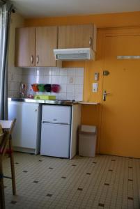 una cucina con elettrodomestici bianchi e una porta gialla di Au Coeur de Bourg CSM a Courseulles-sur-Mer