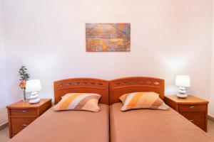 a bedroom with two beds and two night stands at Divine Apartment in Karpathos