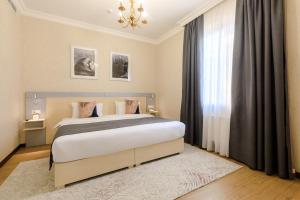 a bedroom with a large bed and a window at Navruz Hotel Tashkent in Tashkent