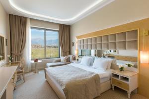 Cette chambre comprend un grand lit et une grande fenêtre. dans l'établissement Gabala Garden Hotel, à Qabala