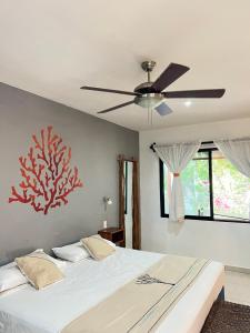 een slaapkamer met een bed en een plafondventilator bij Maya Eco Village in Akumal