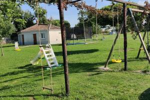 a playground with swings in a park at LE MEDOC AUX 4 VENTS in Jau-Dignac-et-Loirac