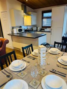 a dining room table with plates and wine glasses on it at #3 Delightful 3 bedroom lodge - holiday home, No Hot tub 