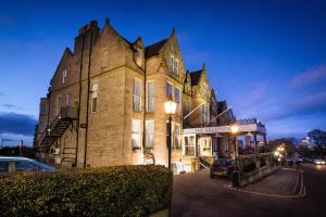 un viejo edificio con un coche aparcado delante de él en The Bruntsfield Hotel, en Edimburgo