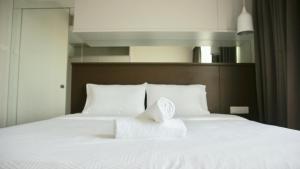a white bed with white sheets and pillows at Verve Suites KL South in Kuala Lumpur