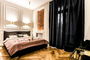 a bedroom with a bed and a black curtain at Luxury Jacuzzi Apartment in Krakow
