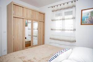 um quarto com uma cama e um armário de madeira em Apartman Barbara em Trogir
