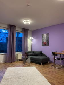 1 Room, near to UN und Telekom في بون: غرفة معيشة مع أريكة وجدار أرجواني