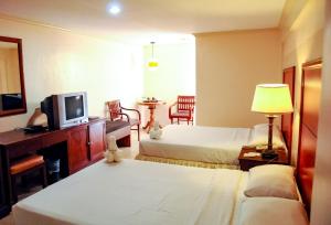 Säng eller sängar i ett rum på Crown Regency Residences Davao