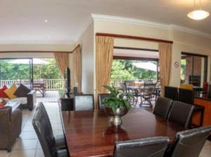 un soggiorno con tavolo e sedie in legno di Marula Mews T17 Villa - Selborne Golf Estate a Kelso