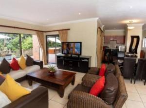 un ampio soggiorno con divani e televisione di Marula Mews T17 Villa - Selborne Golf Estate a Kelso
