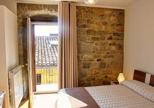 a bedroom with a bed and a stone wall at Il Casale del Borgo in Cancellara