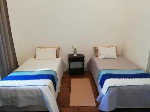twee bedden in een kamer met een tafel bij Casa Dona Joaquina in Reguengos de Monsaraz